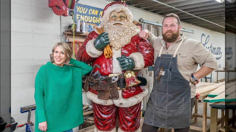 Erin and Ben Napier smiling with a Santa statue