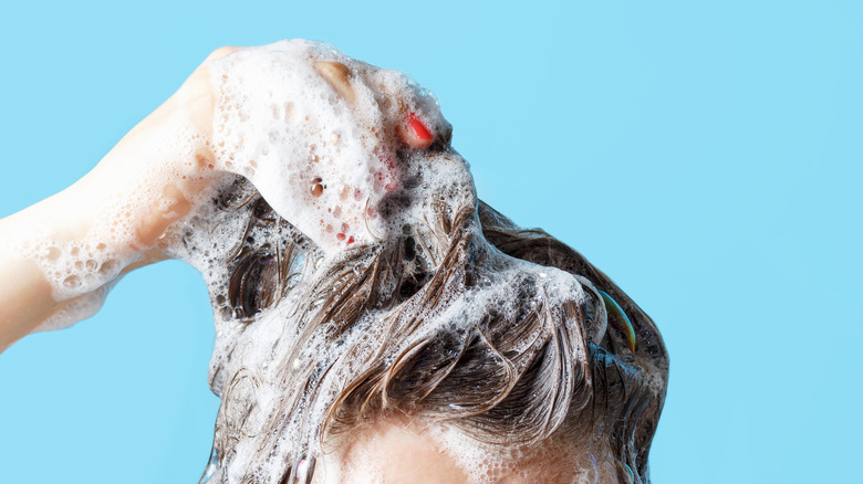 Woman washes her hair in the shower