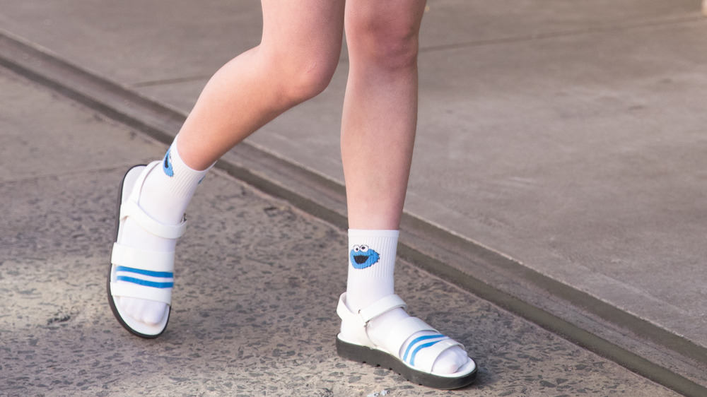 A woman wearing Cookie Monster socks with sandals 