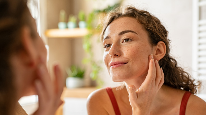 woman smiling and looking in the mirror