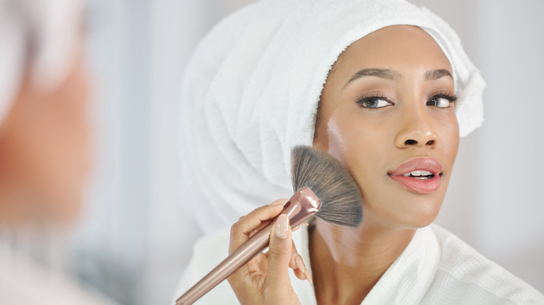 Woman applying makeup with a brush