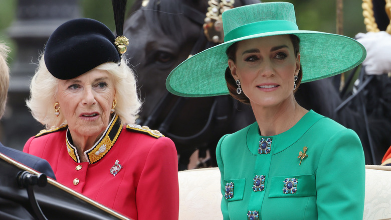 Queen Camilla and Kate Middleton sit in carriage together, looking in same direction