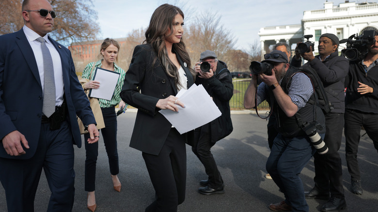 Kristi Noem being followed by reporters