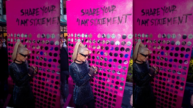 Paris Hilton standing by display board for #THISISWHOIAM campaign