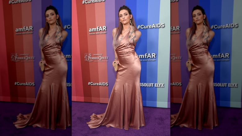 Paris Jackson posing on step-and-repeat in long, silk gown