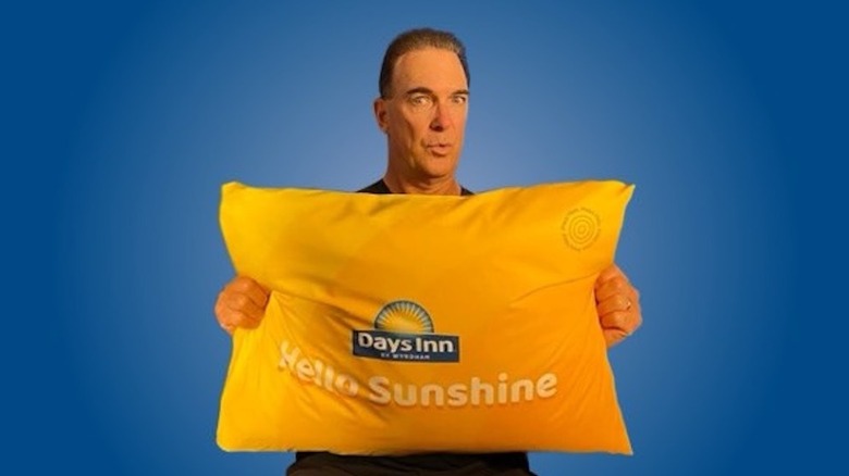 Patrick Warburton holding Days Inn complimentary pillow