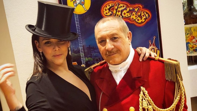 Pauline Ducruet poses in a black top hat next to a ringmaster at the circus.