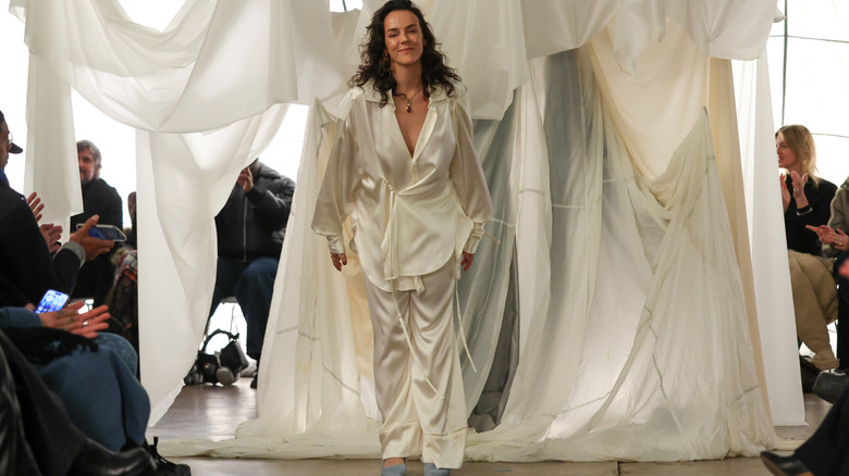 Pauline Ducruet smiles in all white on the runway of her show during Paris Fashion Week.