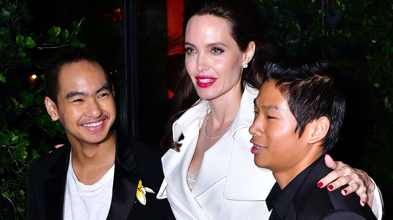 Maddox Jolie-Pitt, Angelina Jolie, and Pax Jolie-Pitt stand together