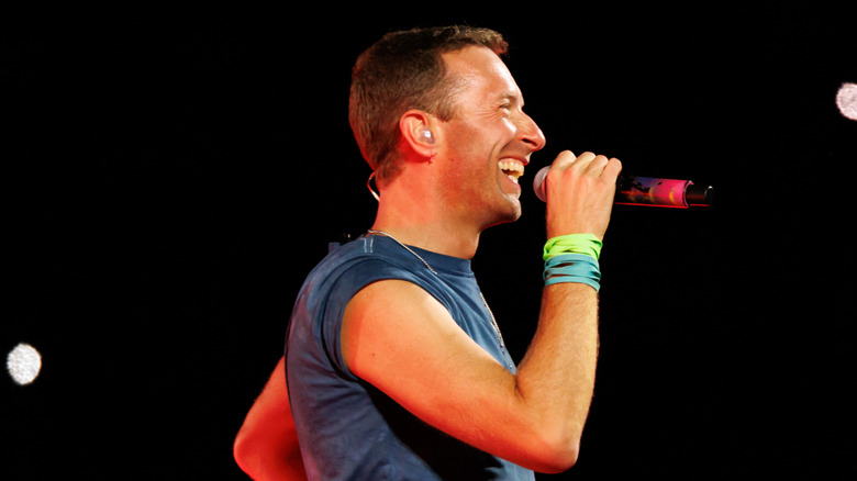 Chris Martin smiling into microphone on stage