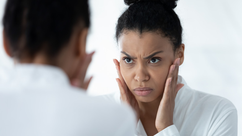 Woman frowning in mirror