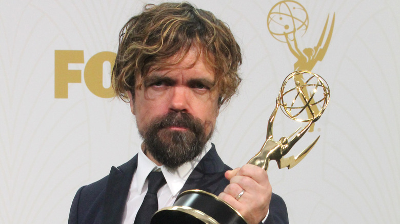 Peter Dinklage posing with an Emmy Award