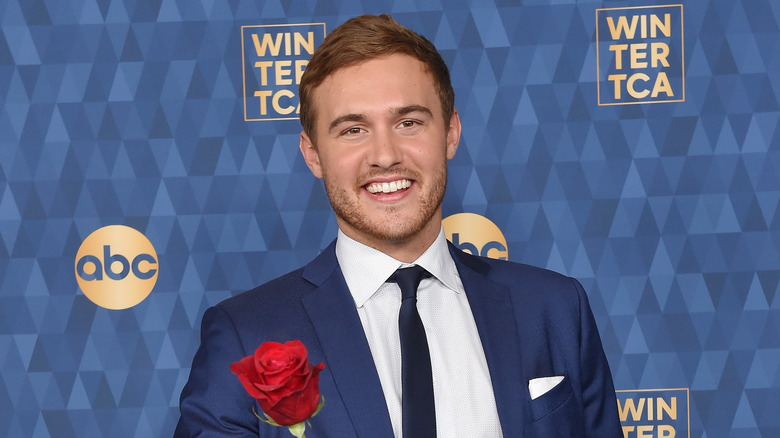 Peter Weber holding rose and wearing blue suit