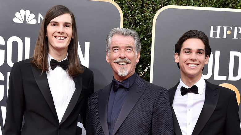 Pierce, Dylan, and Paris Brosnan smile on the red carpet together at the Golden Globes in tuxes.