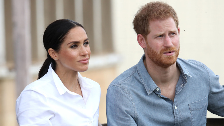 Meghan and Harry listen during an interview