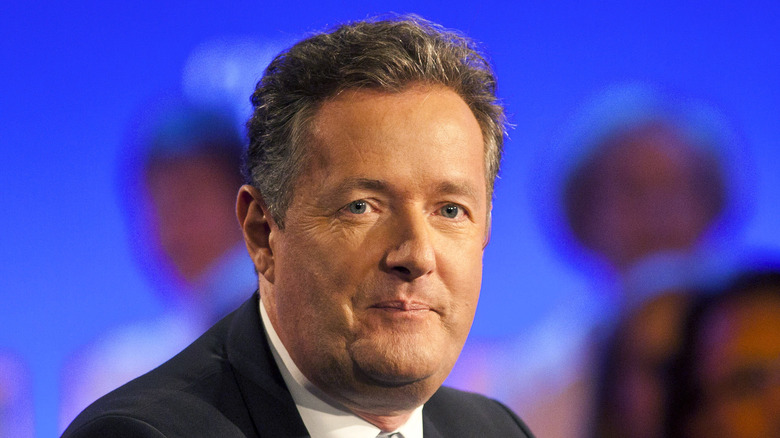 Piers Morgan sits at an event