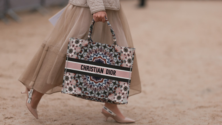 woman carrying christian dior tote