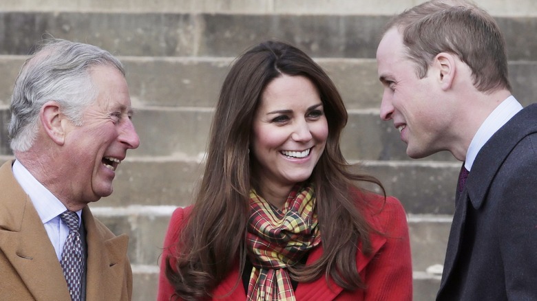 King Charles laughing with Kate and William