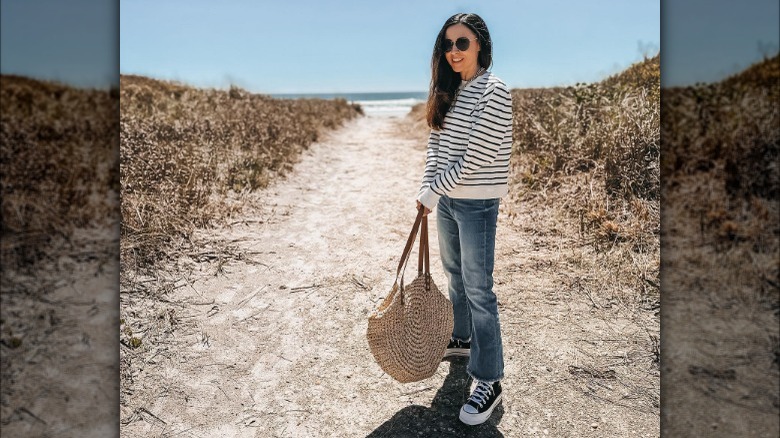 Woman at the beach in striped shirt and jeans