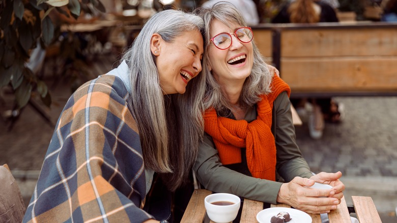 Two older women hugging and laughing