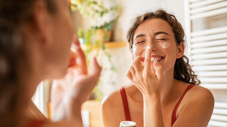 Woman applying moisturizer