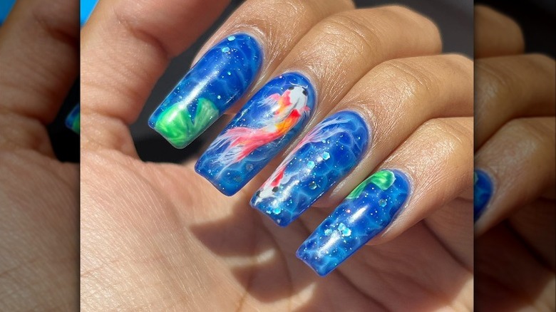 closeup of pool water nails with fish nail art