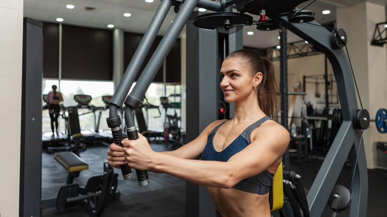 Fit woman using the pec deck machine