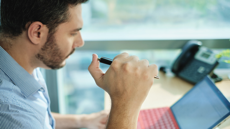 man clicking pen