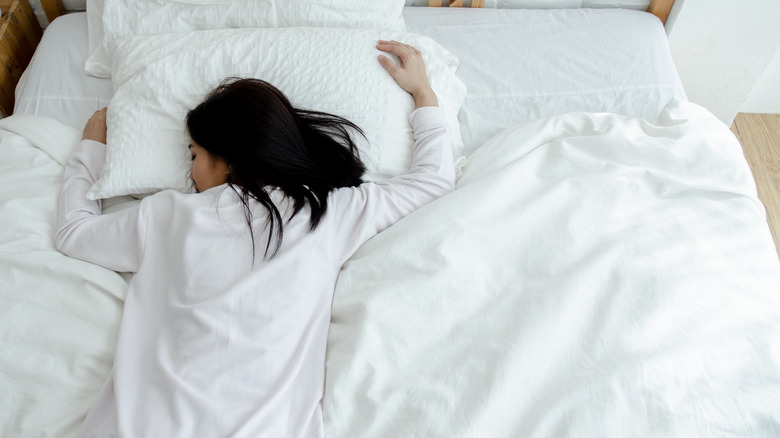 A woman sleeping face down in bed, a posture mistake