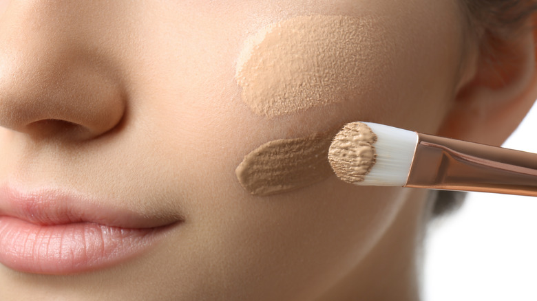 Woman applying liquid foundation