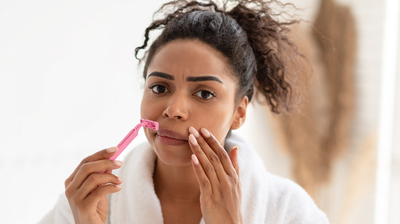 woman shaving her upper lip