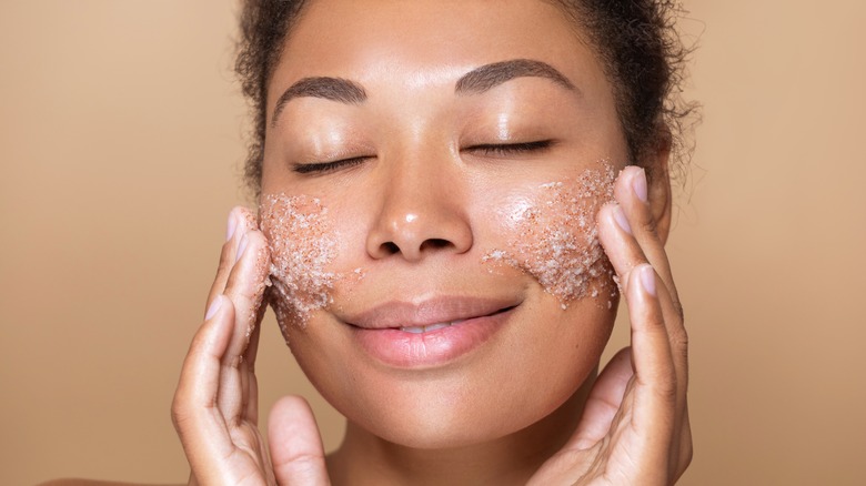 A woman using a face scrub