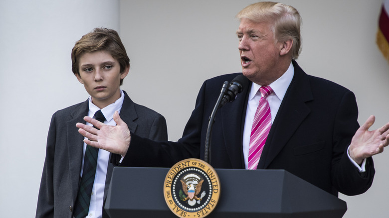 Barron Trump with Donald Trump speaking into mic