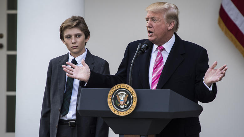 Barron Trump with Donald Trump speaking into mic