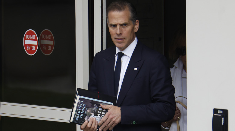 Hunter Biden leaving building holding books