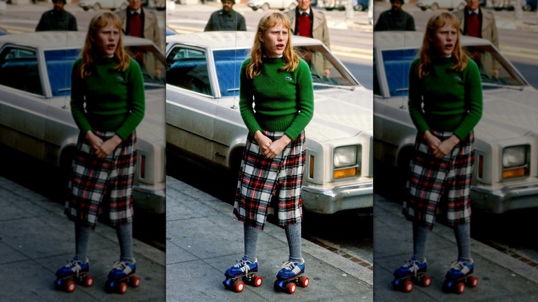 Young Amy Carter on street in roller skates