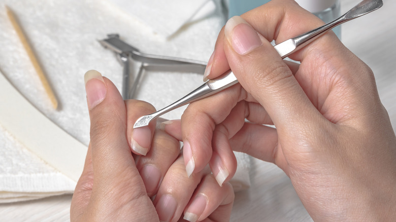 hands using cuticle pusher