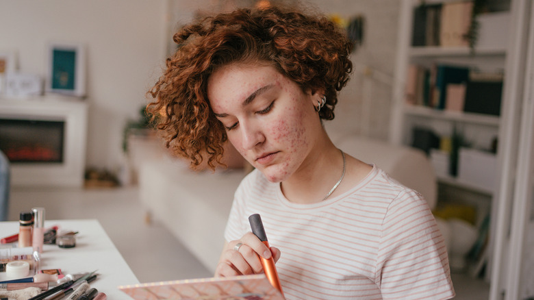 Woman with acne doing skin