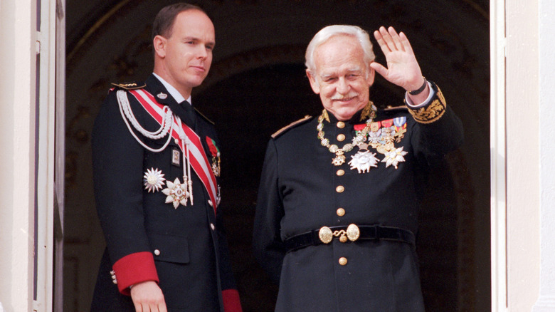 Prince Rainier waving with Prince Albert on balcony