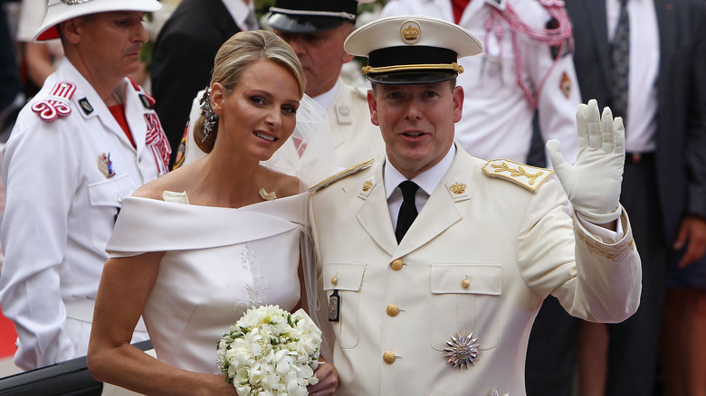 Prince Albert and Princess Charlene seated and waving