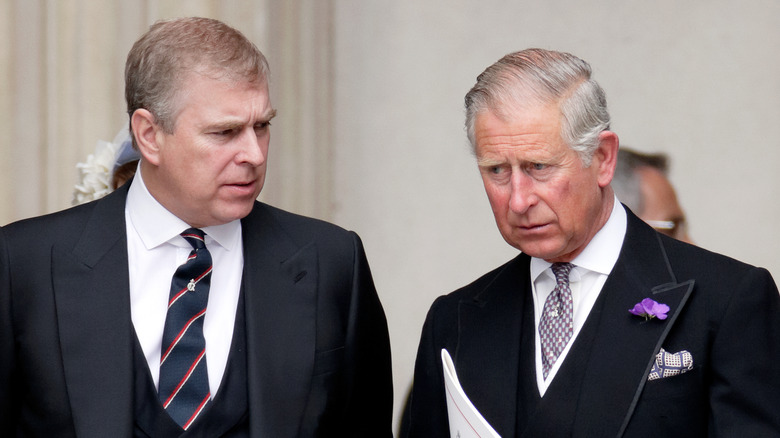 Prince Andrew talking to unhappy-looking King Charles