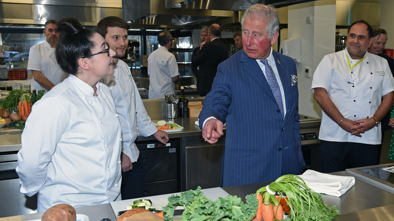 Prince Charles with produce in restaurant kitchen