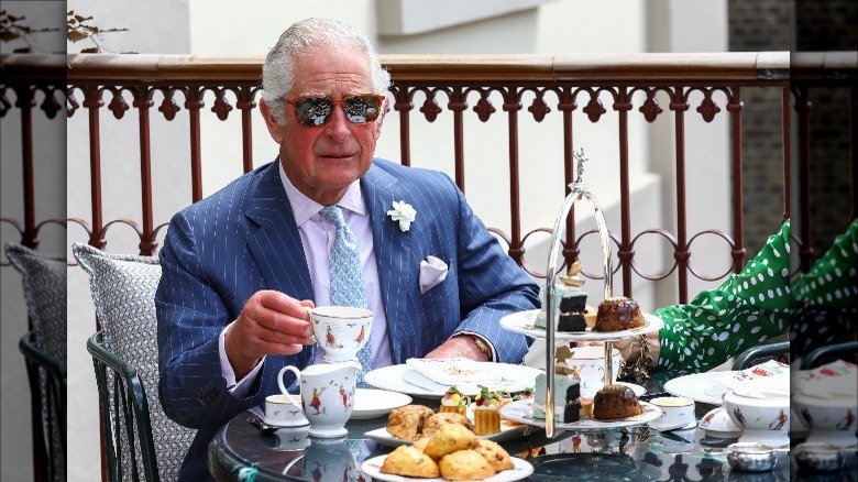 Prince Charles chilling with sunglasses on and sipping tea