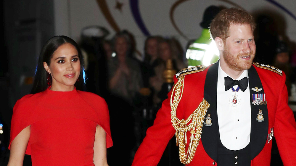 Prince Harry and Meghan Markle wearing red outfits