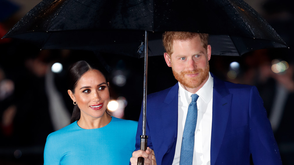 Prince Harry and Meghan Markle under an umbrella