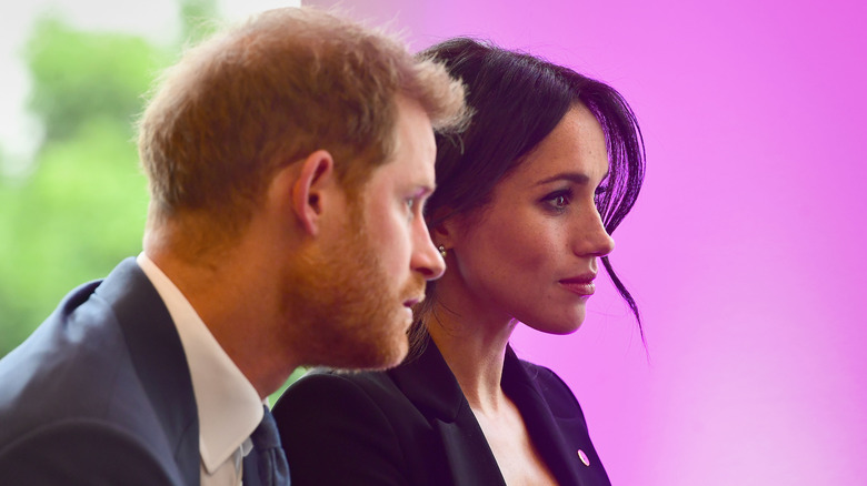 Prince Harry and Meghan Markle listening at event