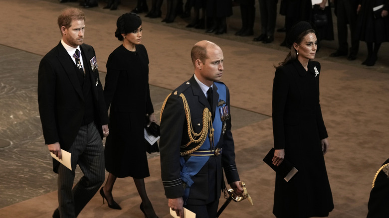 Prince Harry and Meghan Markle hold hands at the queen's funeral event