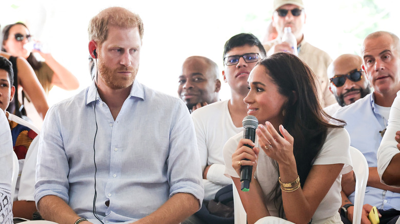 Prince Harry looking at Meghan Markle speaking