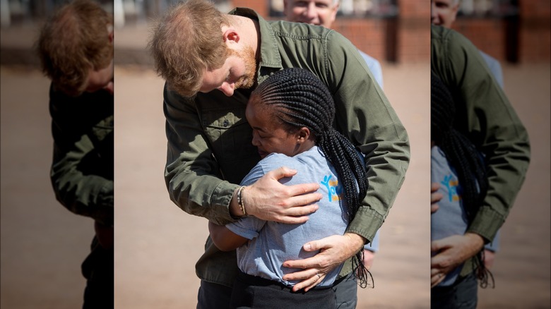 Prince Harry hugging a child