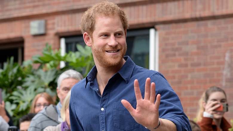 Prince Harry smiling and waving to fans